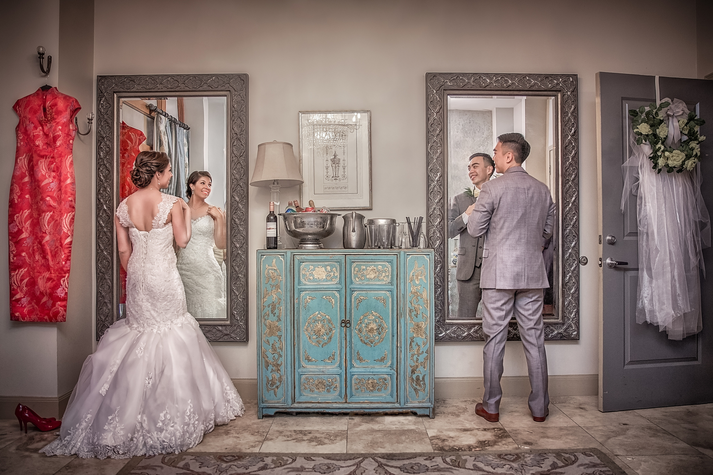 Bride and groom reflected in mirrors while preparing for their wedding